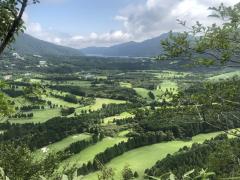 山道で木の隙間から見えるゴルフ場
