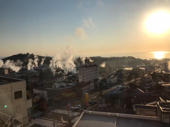 夕日と所々湯が沸く別府温泉のイメージ画像