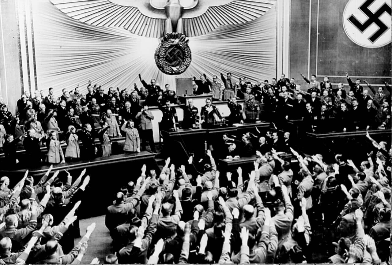 1934年、国会議事堂で演説したアドルフ・ヒトラーと敬礼するナチス党員
