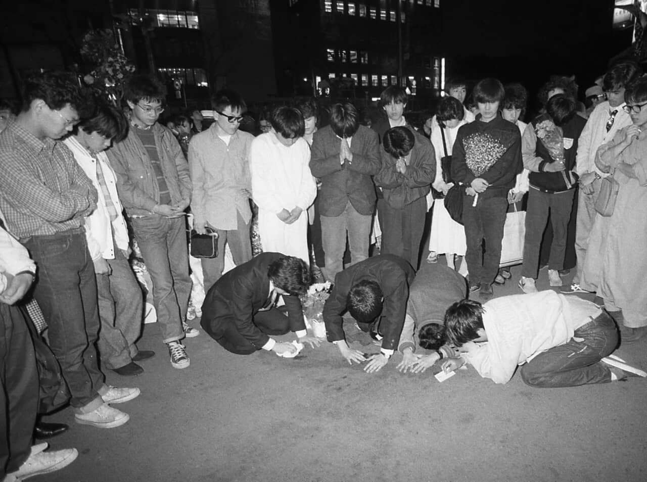 1986年、岡田有希子の自殺現場となったサンミュージック（当時）前。血痕が残る路上に集まり悲しむファンたち